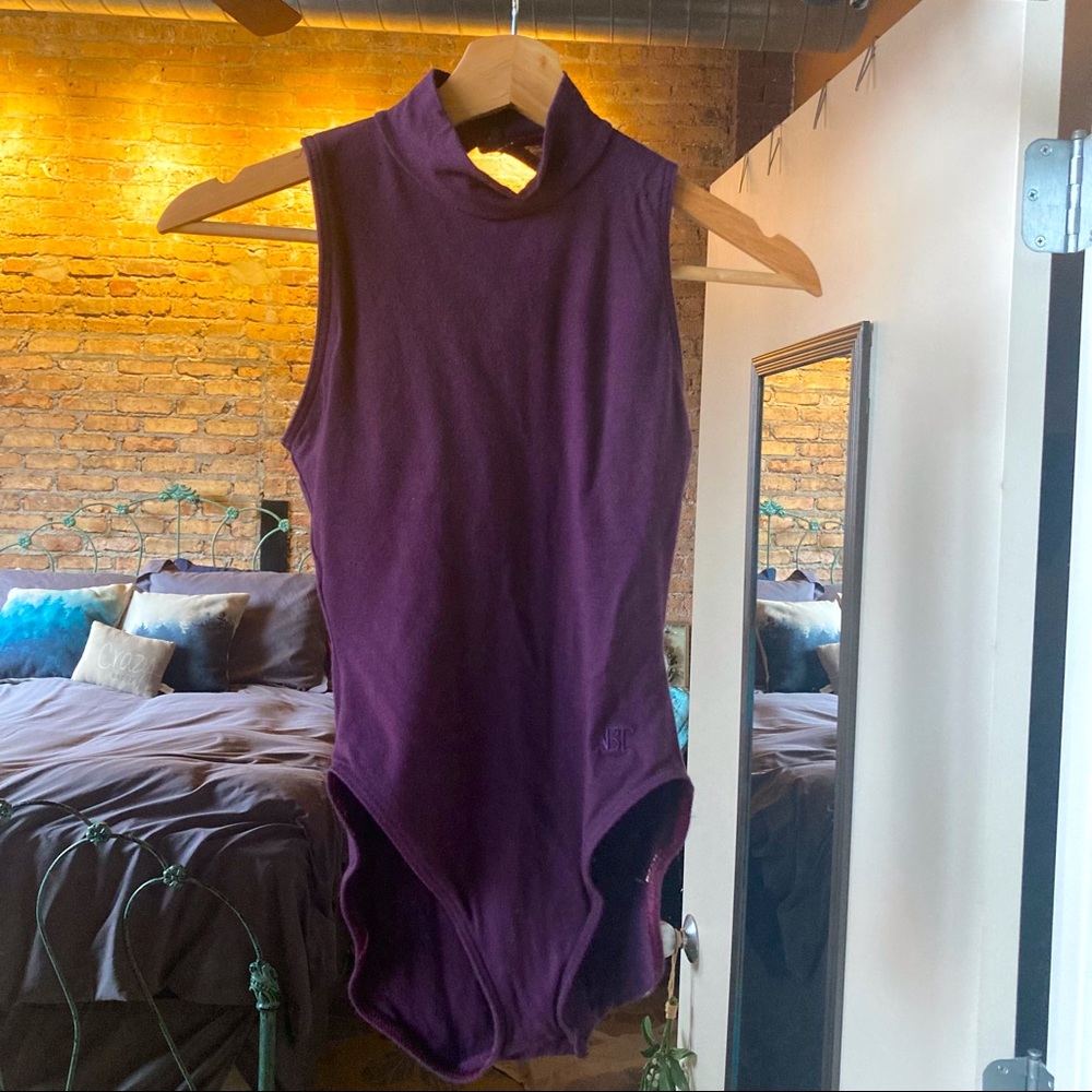 Purple sleeveless turtleneck bodysuit.